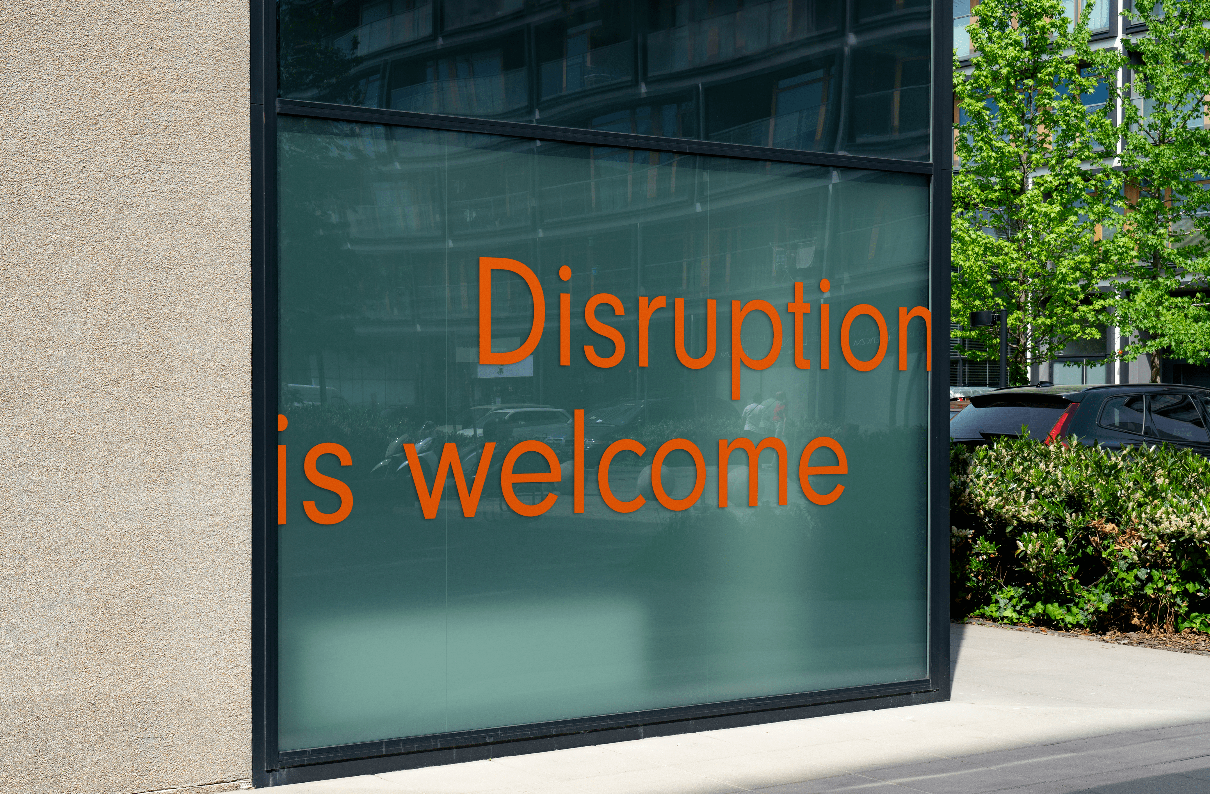 'Disruption is welcome' in orange text on a green window